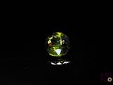 a close up of a green glass ball on a black surface