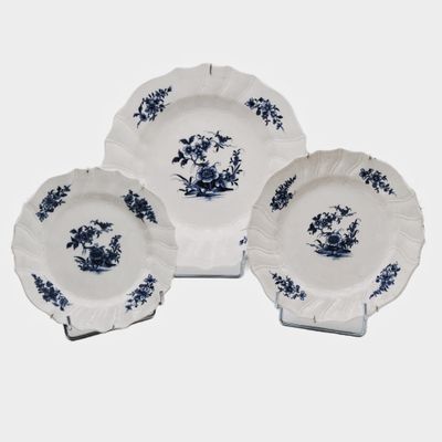 three blue and white plates with blue flowers on them on a white surface