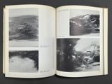 an open book with black and white images of a storm