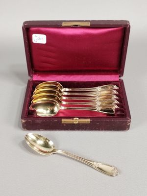 an assortment of silverware in a case with a spoon and spoon rest