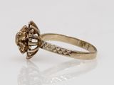 a yellow gold ring with a brown diamond in the center