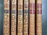 cinq vieux livres alignés sur une table