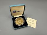 an image of a gold coin in a box with a card