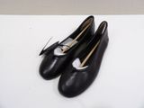 pair of black leather shoes with white bows on them sitting on a white surface