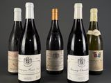 four bottles of wine are lined up on a table