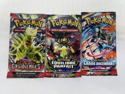 three packs of pokemon trading cards on a white background