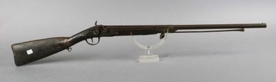 an old gun with a wooden barrel on a clear stand