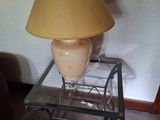 une lampe posée sur une table en verre, sur laquelle se trouve une autre lampe