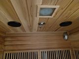 three speakers on the ceiling of a sauna room