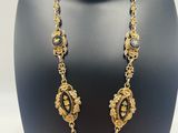 a black and gold necklace on a mannequin display
