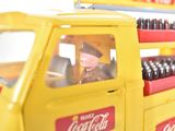 a yellow coca cola truck with a man in the back
