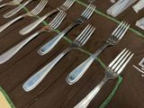 many forks and spoons laid out on a table