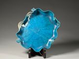 a close up of a blue plate on a stand on a table