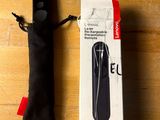a black remote control sitting on a table next to a black bag