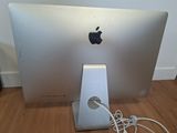 an apple computer sitting on top of a wooden floor next to a wall