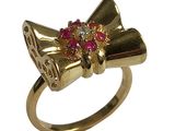 une bague en or ornée d'un nœud rouge et blanc