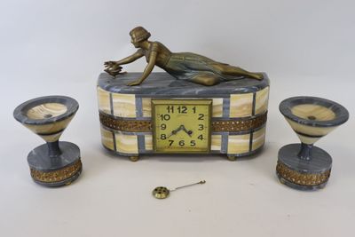 a statue of a woman laying on a table next to a clock