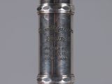a close up of a silver metal object with writing on it