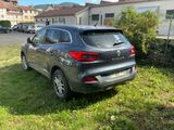 the back end of a grey car parked in a grassy area