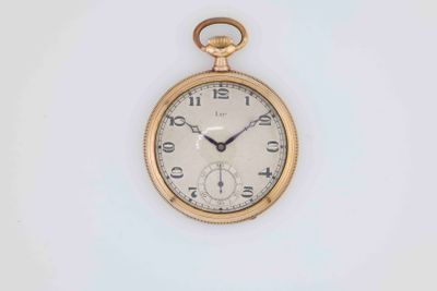 a gold pocket watch with roman numerals on the face