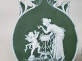 a green vase with a picture of a woman and a child on it