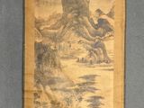 an old scroll hanging on a wall with a painting of a mountain