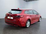 the rear end of a red toyota corollant parked in a room