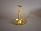 a gold candle holder on a table with a white background