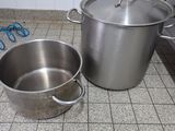 des casseroles et des poêles posées sur le carrelage d'une cuisine