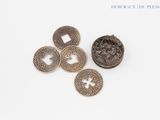 four pieces of silver metal buttons on a white surface