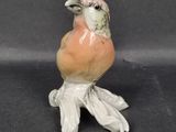 a figurine of a bird sitting on a branch