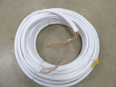 un rouleau de fil électrique blanc posé à même le sol