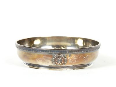 un bol en argent orné d'une croix sur un fond blanc