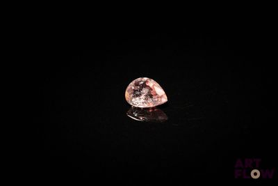 un diamant rose sur une surface noire