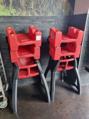 two red high chairs that are next to each other