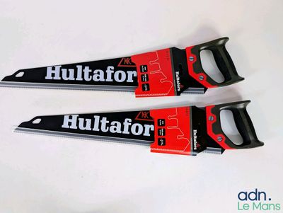 deux scies à main noires et rouges posées sur une table blanche