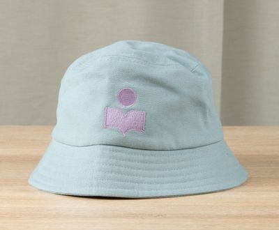 a blue hat with a pink logo on it sitting on a table