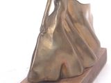 statue of a woman in a long dress on a wooden base