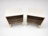 two white nightstands with drawers on each side of them