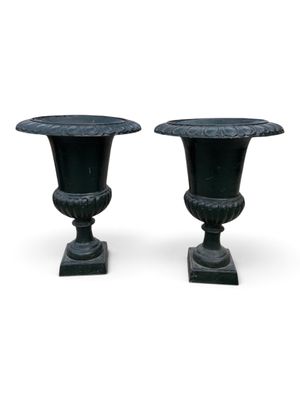 pair of black urns on pedestals on a white background