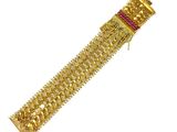 a close up of a gold bracelet on a white background