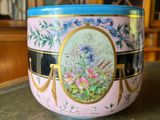 a pink bowl with a blue lid sitting on a table
