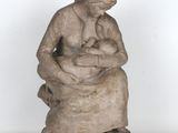 statue of a woman holding a baby sitting on a rock