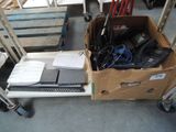 une boîte contenant des appareils électroniques posée par terre à côté d'un carton