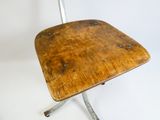 une petite chaise en bois avec des pieds en métal sur fond blanc