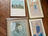 four framed pictures on the floor of a room