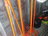 orange poles that are on the floor next to a wall