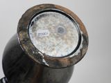 a close up of a metal vase with a label on it