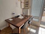 une table en bois avec deux chaises et une chaise placée devant une fenêtre