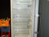 an open refrigerator in a dark room with bottles of beer